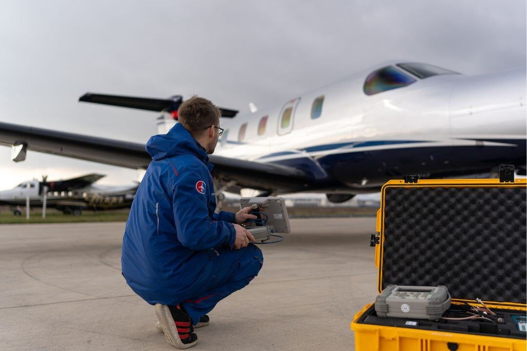 AIR TEAM technician testing aircraft systems with a portable test set at Kunovice